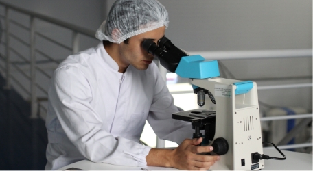 researcher looking into microscope